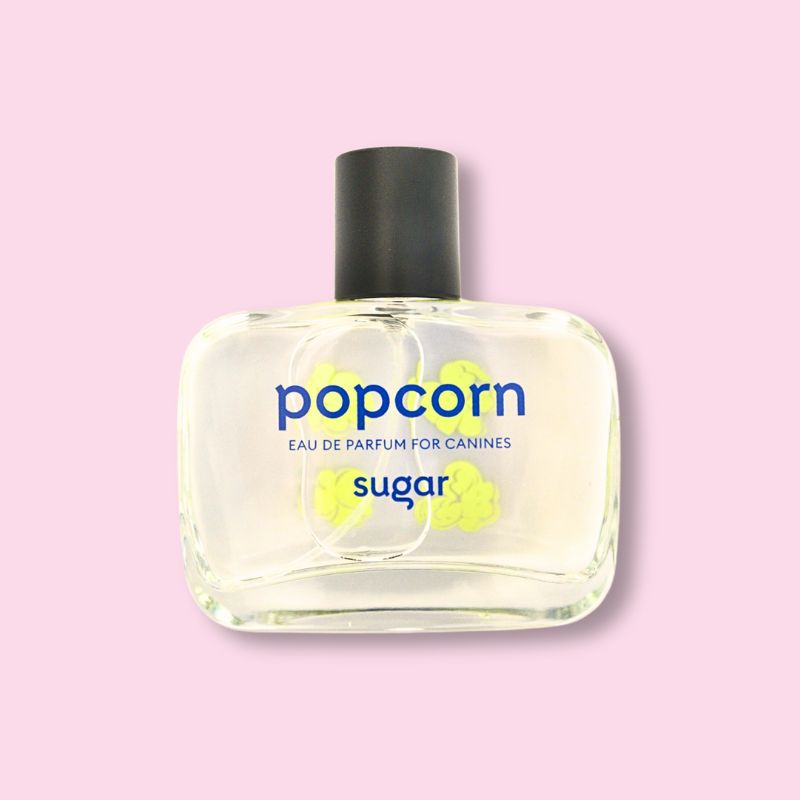Bottle of Sugar Popcorn Eau de Parfum for canines, luxury dog perfume styled on a pink background